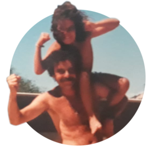 A man holds his daughter on his sholders as they laugh